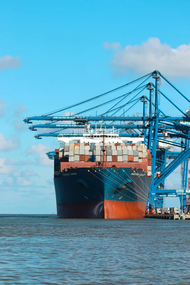 Cargo ship docked at a port with container cranes